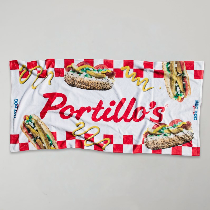 Portillo's beach towel with hot dog graphics and red checkered picnic pattern.