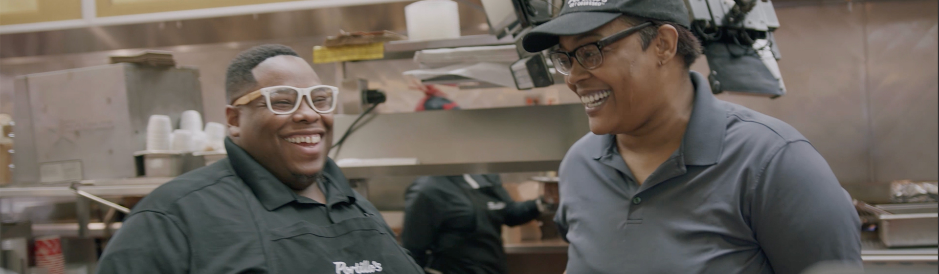 two employees smiling in the kitchen
