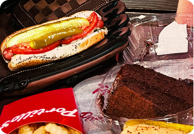 baseball mitt holding a hot dog and a slice of chocolate cake